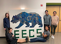 EECS grads students pose by the finished artwork.