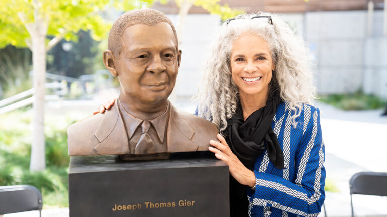 Artist Dana King poses with the newly unveiled Joseph Thomas Gier Memorial statue on September 20th, 2023.