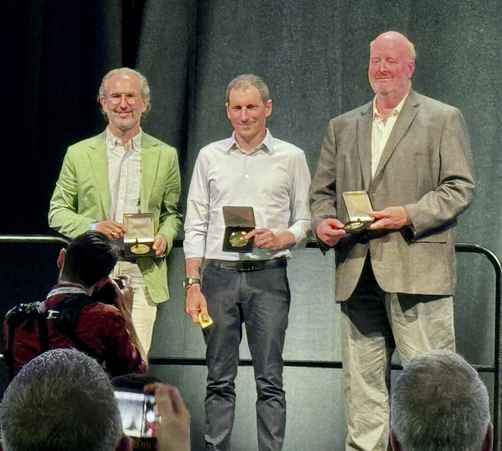 Miki Lustig holding the ISMRM Gold Medal, along with two other medal recipients.